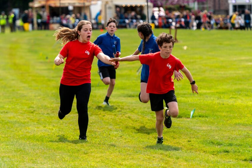 Children pass the baton in the relay race.