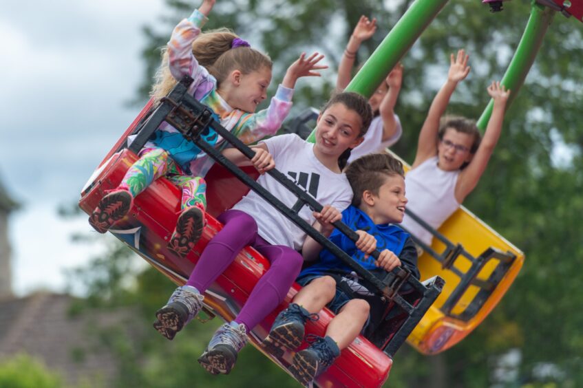 Children smiling on a funfair ride