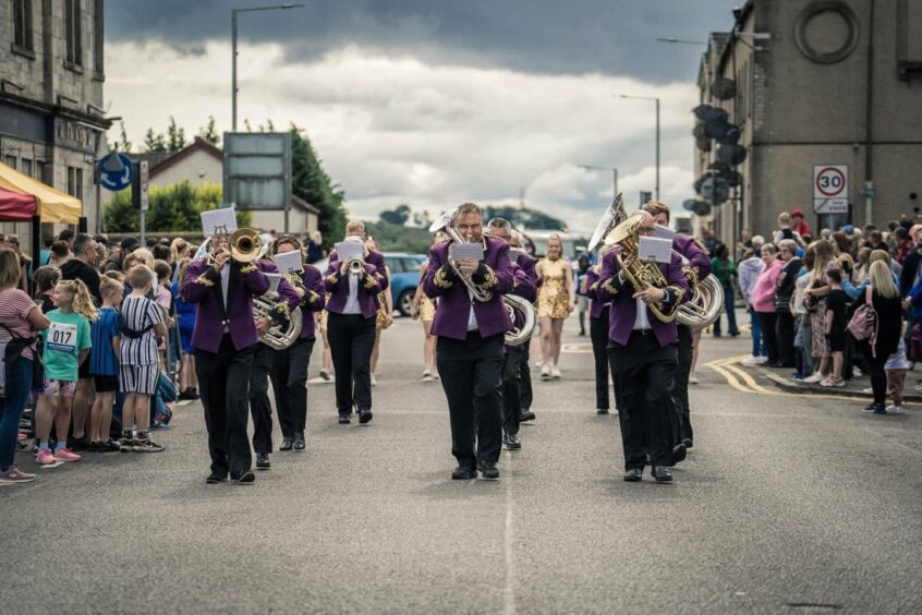 Image shows: Kingdom Brass Band marching on a street in Fife.