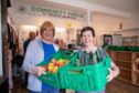 Volunteers Dorothy Culloth (left) and Barbara Lindsey with some of the food available to community fridge clients. Image: Kenny Smith/DC Thomson