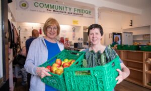 Volunteers Dorothy Culloth (left) and Barbara Lindsey with some of the food available to community fridge clients. Image: Kenny Smith/DC Thomson