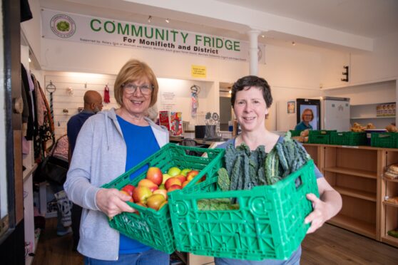 Volunteers Dorothy Culloth (left) and Barbara Lindsey with some of the food available to community fridge clients. Image: Kenny Smith/DC Thomson