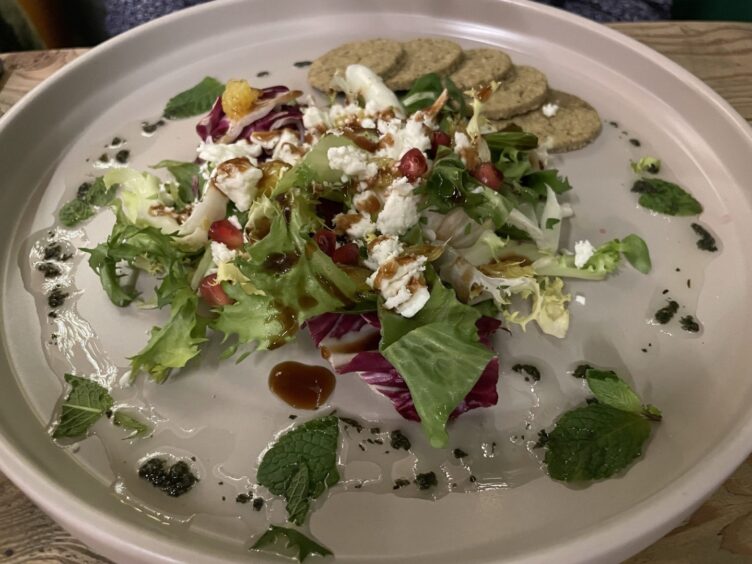 A light orange and feta salad on a white plate with 5 small oat cakes.