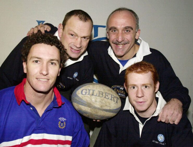 Mike McKenzie, Kenny Milne, Allan Johnston and Chris McConnell pose for a picture with a rugby ball. 