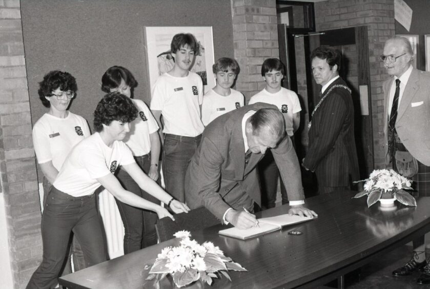 Prince Philip signing the book at Whitfield High. 