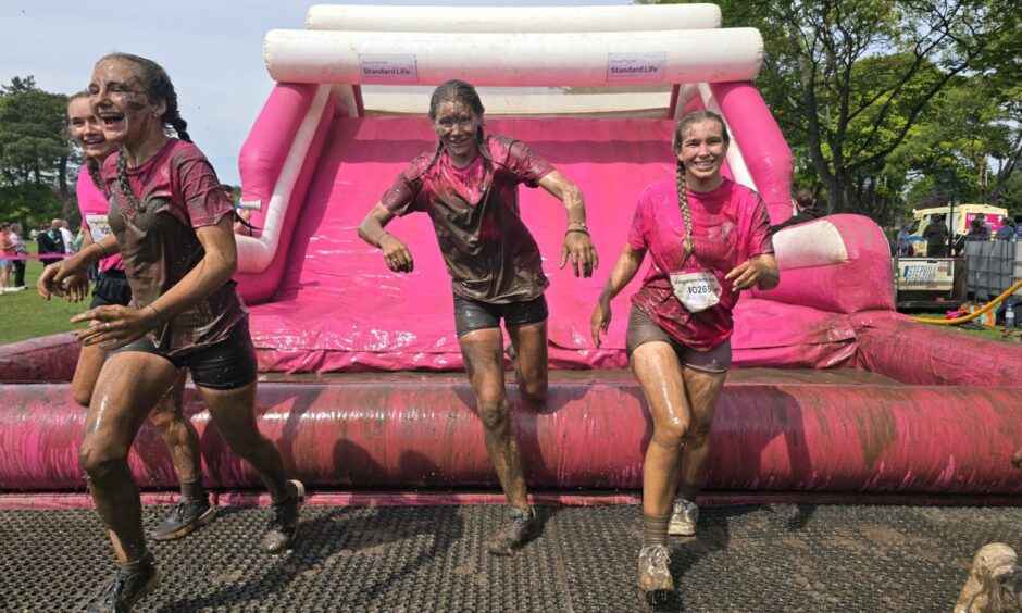 Participants climbing out of the mud filled pit at the finale of Pretty Muddy