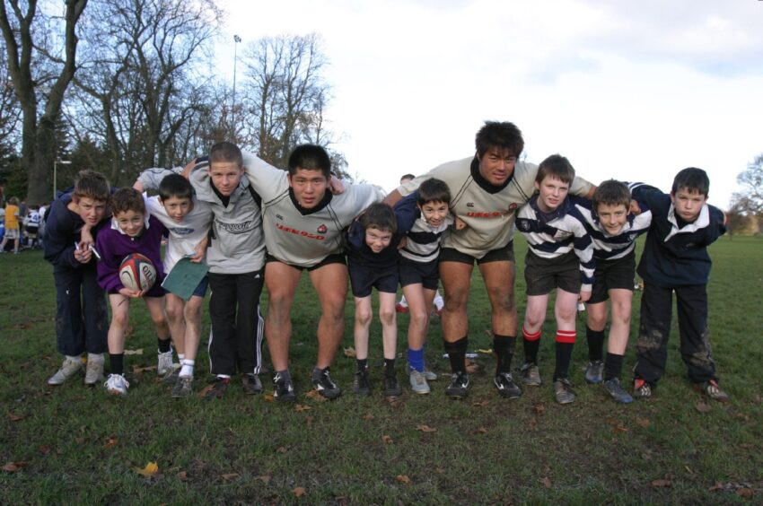 Two Japanese players get their picture taken with the kids