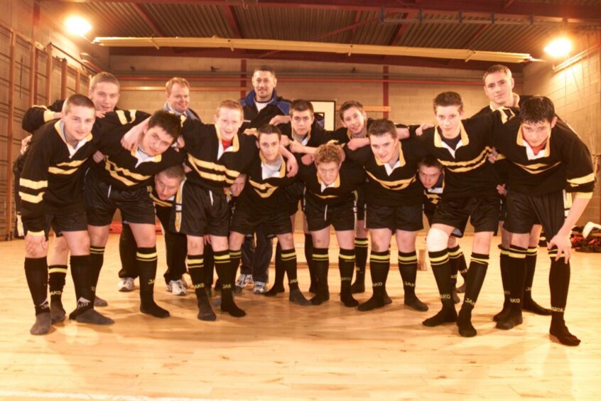 The boys pictured in their new kit (black with yellow trim) alongside assistant coach Jim Conn (back left) and Perthshire rugby coach Sam Kaleta.