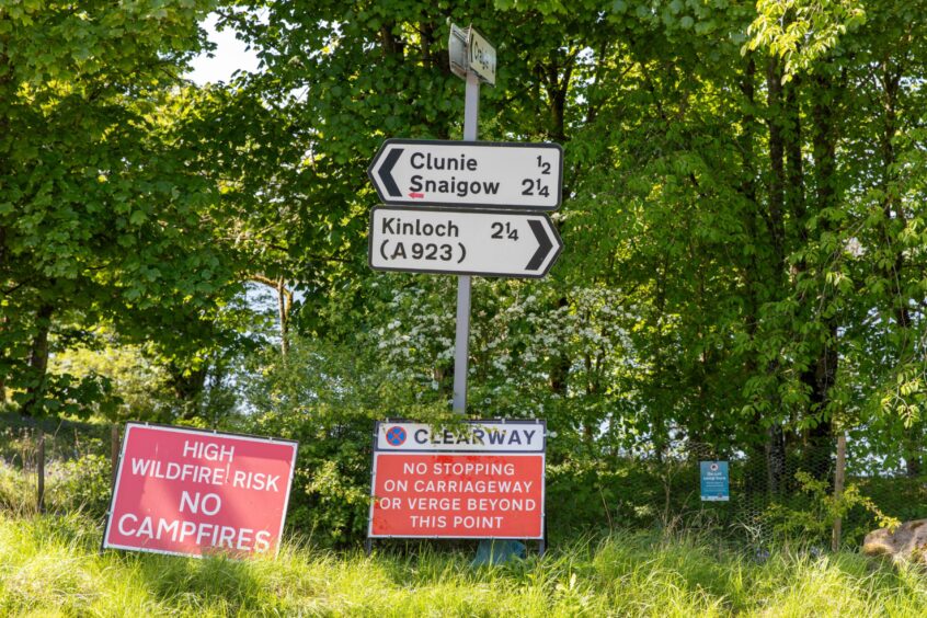 Riad signs pointing to Kinloch and Clunie, with signs below warning 'no campfires' and 'no stopping on carriageway or verge beyond this point'.