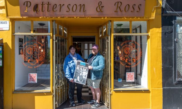 Yvette Hoskins and Rob Patterson (owner) outside Patterson & Ross Barbers holding the up The Courier's posters. Image: Richard Hancox/DC Thomson