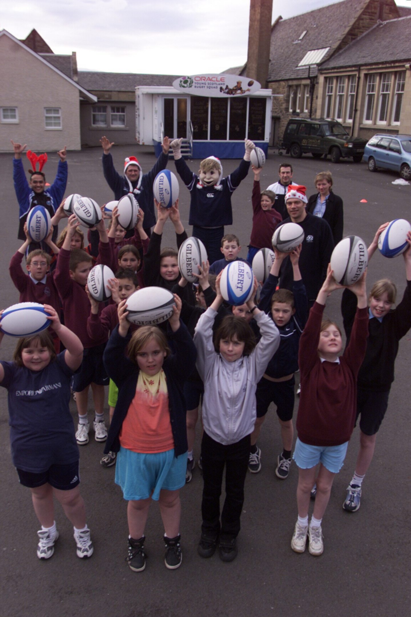 Pupils in the playground holding up rugby balls as The Fife Rugby Development team visits West Primary in Kirkcaldy in December 2000
