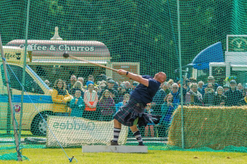 Man in kilt throwing hammer