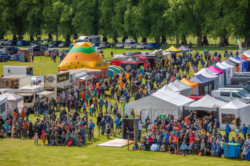 Trade stalls and children's rides with large crowds milling around