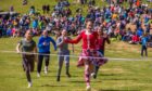 Girl in Highland dancer outfit crossing finishing line in girls race