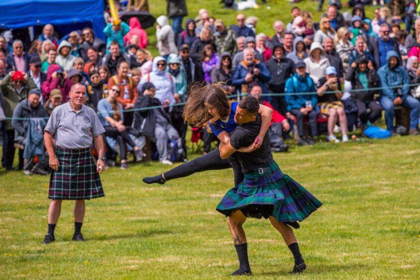 Kilted man wrestling young woman