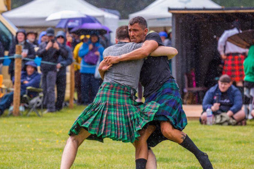 Two men in kilts wresting