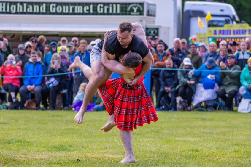 Two people, one in kilt, wresting at Atholl gathering