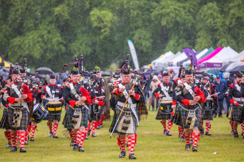 Pipes and drums with Atholl Highlanders behind in main arena at Atholl Gathering