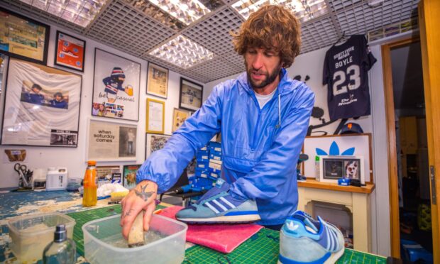 Kris Boyle cleaning up a pair of trainers at his shop, Dundee Sole. Image: Steve MacDougall/DC Thomson.