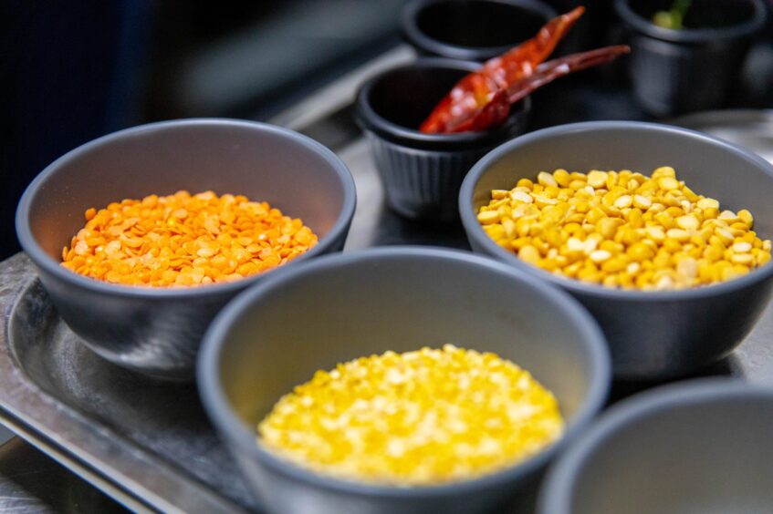 Silver ramekins of lentils and red chillies.
