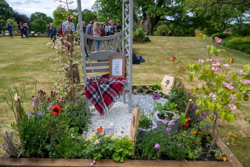 Garden display with poppies and tartan blanket at Scone Palace