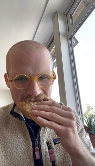 A man eating a toastie.