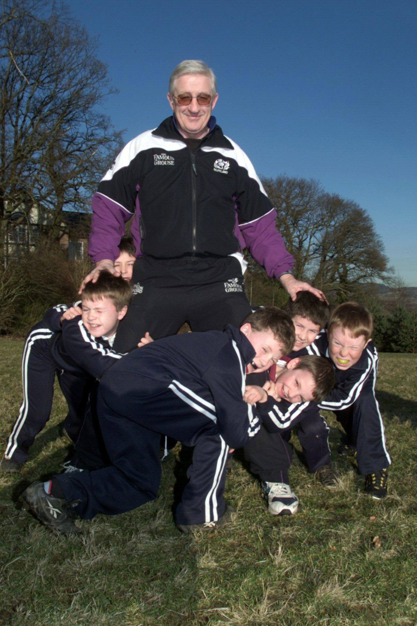 Scotland rugby coach Jim Telfer is tackled by youngsters during a visit to Craigclowan in January 2000.