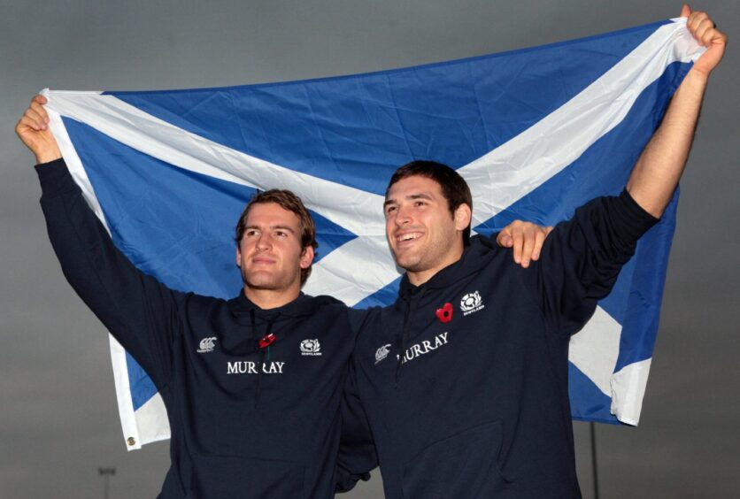 Rory Lamont (left) and Sean Lamont holding up a Saltire flag. 