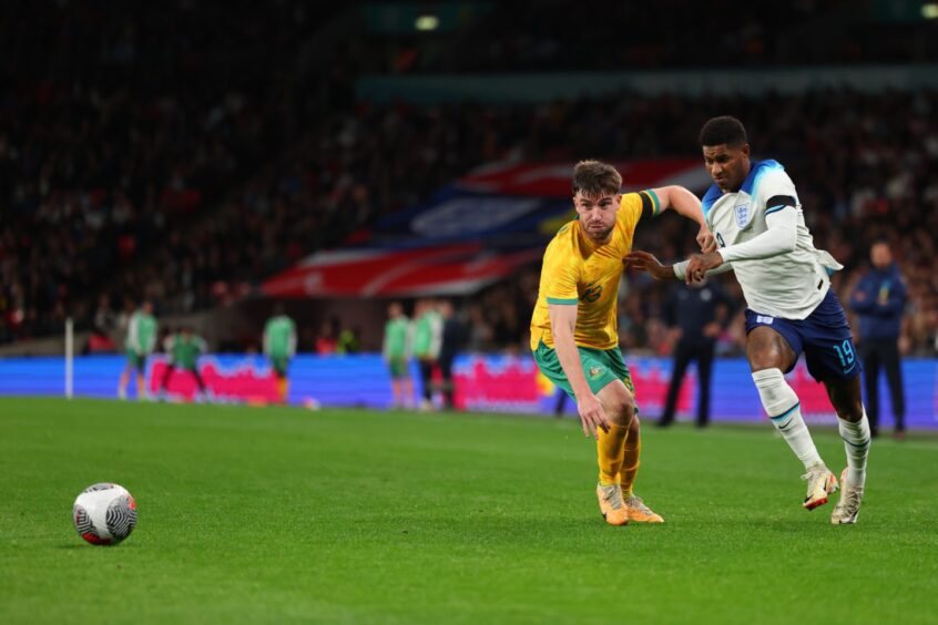 Ryan Strain, left, on Australia duty attempting to mark Marcus Rashford