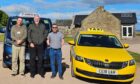Co-owner James Glen with drivers Gary Dent and Stuart Smith standing in front of two taxis.