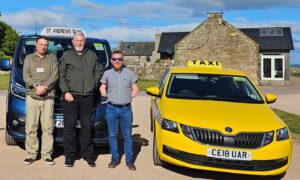 Co-owner James Glen with drivers Gary Dent and Stuart Smith standing in front of two taxis.