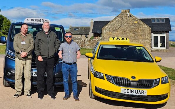 Co-owner James Glen with drivers Gary Dent and Stuart Smith standing in front of two taxis.