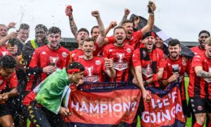 Truro City players celebrate their title triumph.