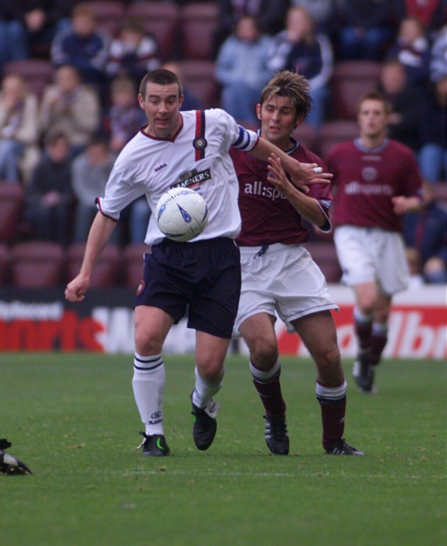 Barry Smith holds off a Hearts player as the ball bounces