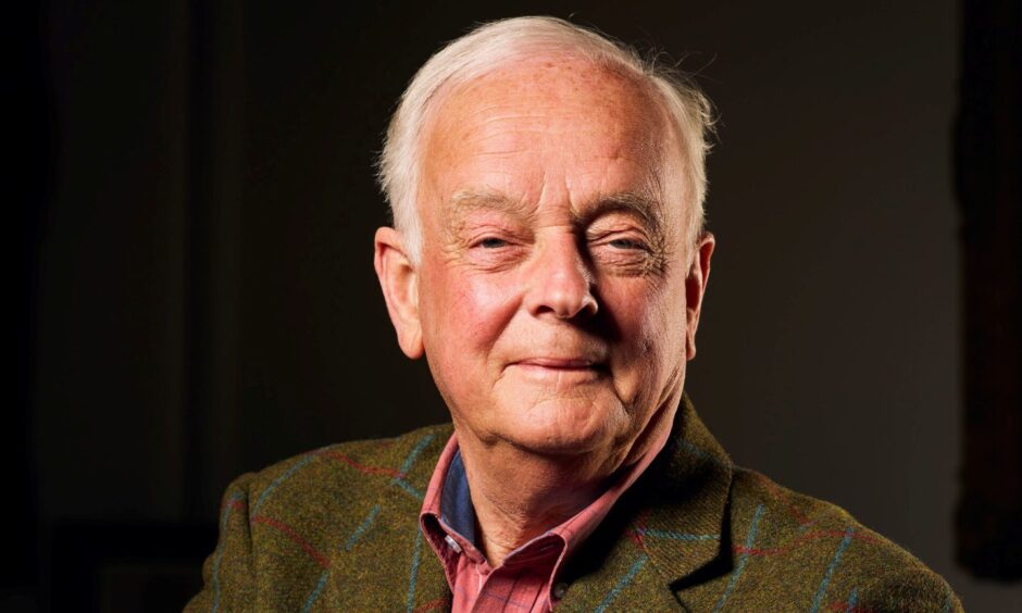 image shows: author Andrew Orr. Andrew is wearing a tweed jacket and red shirt, has receding white hair.