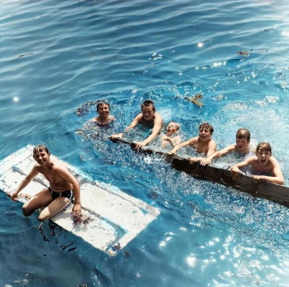 A group of boys cool off in Broughty Ferry harbour in July 1971. One seems to be floating on an old door. 