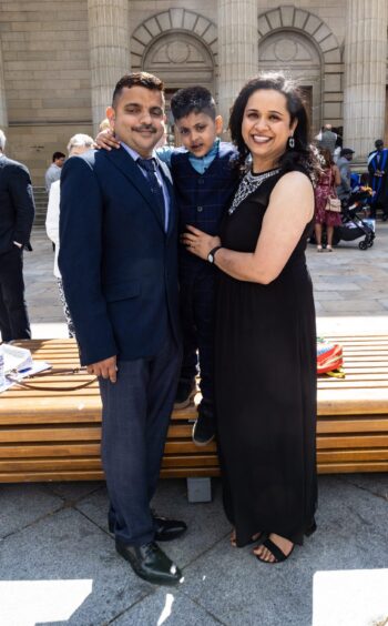 A smiling female graduate with her family. 