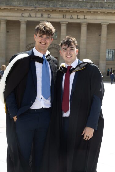 Two male graduates smiling. 