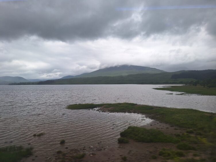 A loch with hills in the background. 