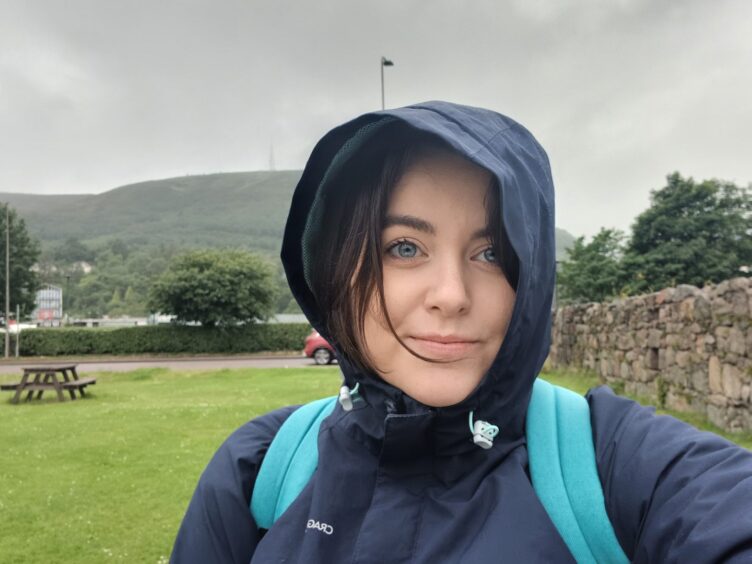 A female reporter in a raincoat. 