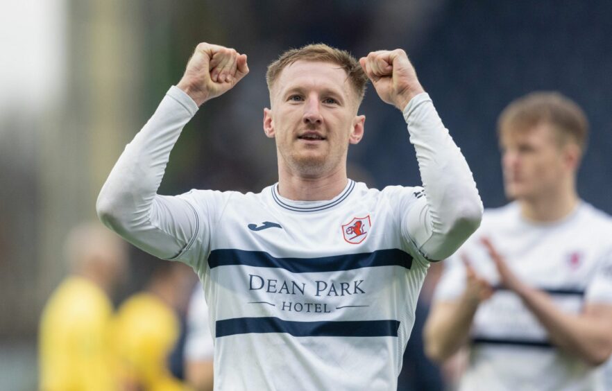 Departing Raith Rovers defender Liam Dick holds up two clenched fists in celebration.