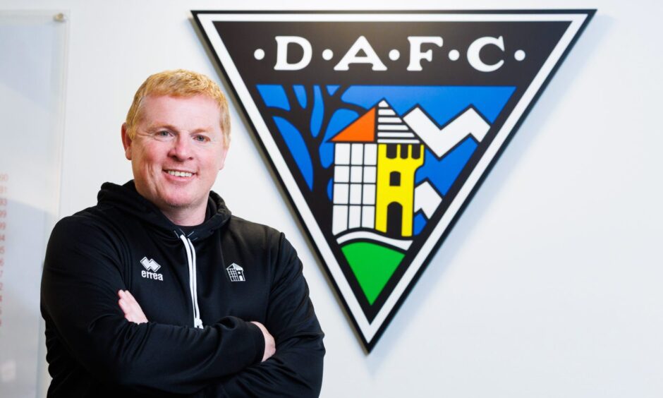 Dunfermline Athletic manager Neil Lennon stands with his arms folded in front of the club badge.