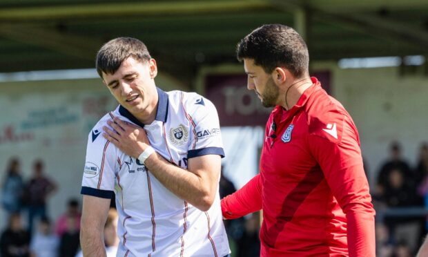 Charlie Reilly gets treatment from Dundee physio Bruce Smith after being forced off against Arbroath. Image: Ross Parker/SNS