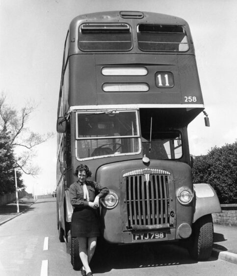 Dundee Corporation's first female bus driver Mrs Brindley next to a bus in 1971. 