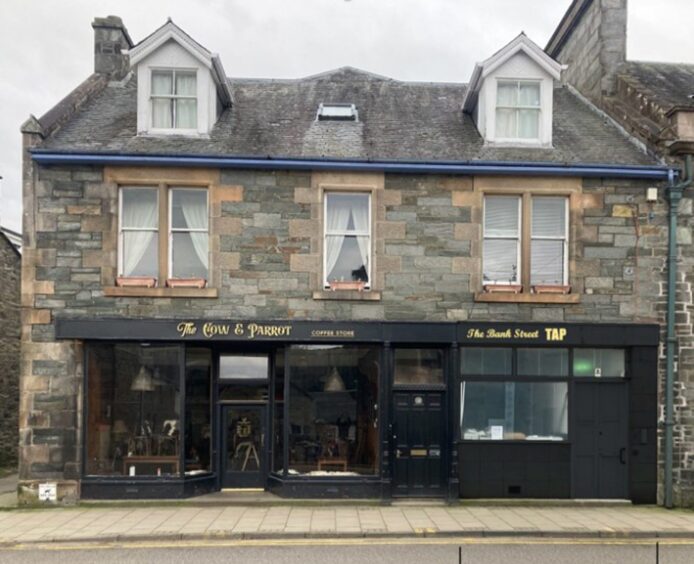 Visualisation of the Cow and Parrot cafe with the unit next door similarly painted black and with gold lettering.