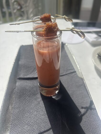 Gazpacho sitting inside a tall glass.