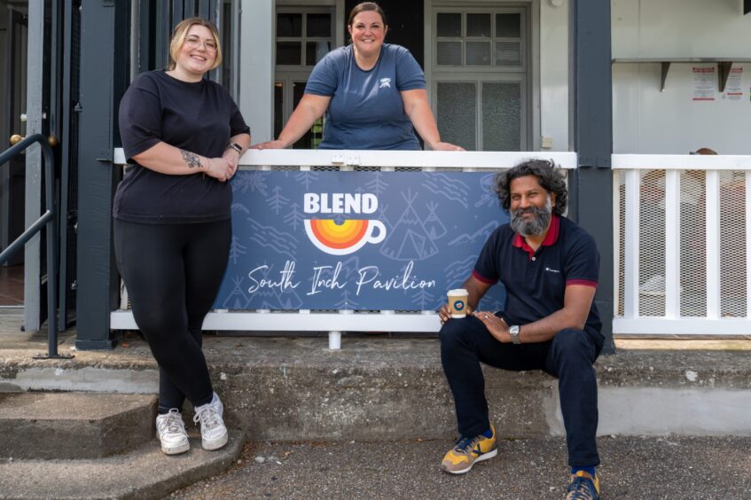 Three people standing and seated around sign for Blend at the South Inch pavilion