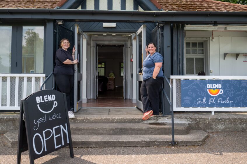 Two women standing at open doors to South inch pavilion, Perth