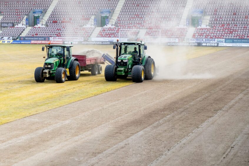 Two tractors work on the East End Park surface.