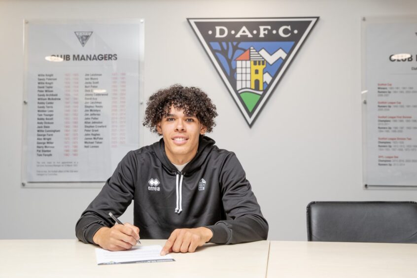 Jeremiah Chilokoa-Mullen puts pen to paper on his new Dunfermline contract in the East End Park boardroom.